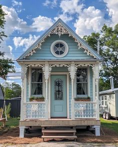 a small blue house sitting on top of a lush green field