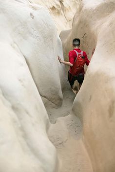 a man climbing up the side of a snow covered mountain