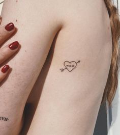 two women with matching tattoos on their backs, one has a heart and the other has an arrow