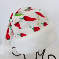 "\"Feliz Navidad\" is the message on this south of the border celebration Santa hat. This festive Santa style hat is made up in an ivory cotton fabric with gold lettering bold red and green chili peppers in the print . The slouch cone style hat is accented with snowy white soft faux fur fabric trim and there is a fluffy white pompom stitched on the top. Proportions of the hat are generous and will fit most head sizes, ladies or gents. Measurement for opening for your head is 26\" circumference a Christmas Party Hat, Las Vegas Christmas, Christmas Party Hats, Adult Christmas Party, Green Chili Peppers, Red Buffalo Check, Bad Santa, Santa Costume, Santa Claus Hat