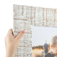 a person holding up an old photo frame