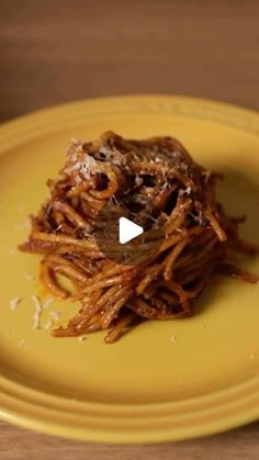 a yellow plate topped with spaghetti and meat