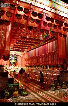 the interior of a temple decorated in red and gold colors with lights on the ceiling