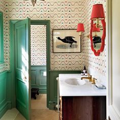 the bathroom is decorated in green and white with red lamps hanging from the light fixture