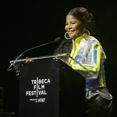 a woman standing at a podium with a microphone in front of her and the words tribeca film festival written on it