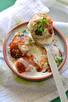 a bowl filled with meatballs covered in sauce and garnished with parsley