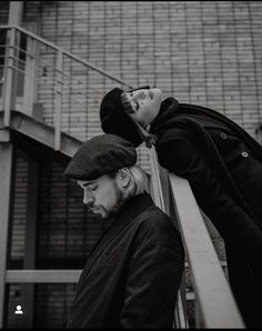 black and white photograph of two people leaning against each other