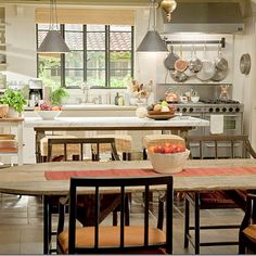 a kitchen with an archway leading into the dining room and kitchen area, along with a table that has chairs around it