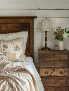 a bed sitting next to a night stand with flowers on it