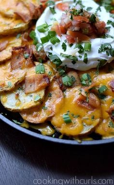 potato wedges with sour cream and bacon in a skillet on a green napkin