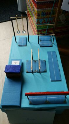 a blue table topped with lots of pieces of paper and wooden dows on top of it