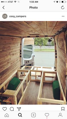 the inside of a van with wooden walls and green cushions