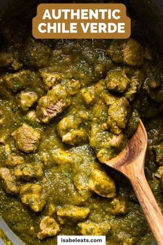 a wooden spoon in a pot filled with green sauce and some meatballs on the side