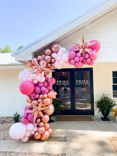 a bunch of balloons that are on the ground in front of a building with a door