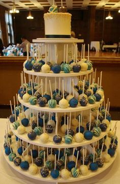 a three tiered cake with blue and white desserts on it's sides