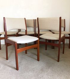 four chairs are arranged in the middle of a room with carpeted flooring and white walls