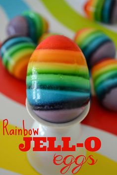 rainbow jello - o eggs sitting on top of an egg holder with the words rainbow jello - o in front of them