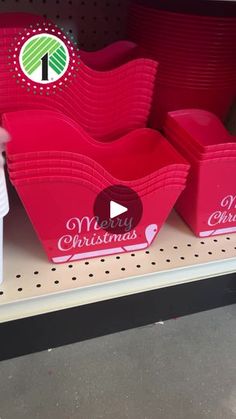 red plastic containers with christmas designs on them are sitting on a shelf in a store