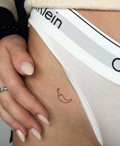 a woman's stomach with a small tattoo on her left side ribcage