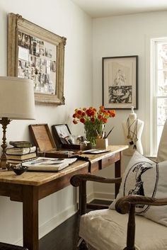 a room with a desk, chair and pictures on the wall