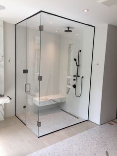 a bathroom with a walk in shower sitting next to a sink and a bathtub