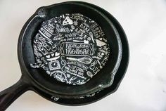 an old cast iron skillet with writing on the inside and outside, sitting on a white surface