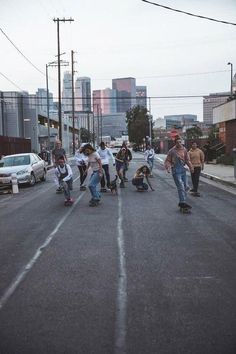 several skateboarders are riding down the street together