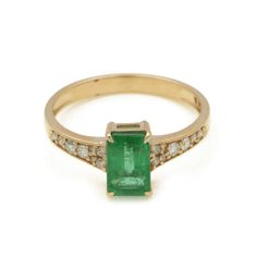 an emerald and diamond ring on a white background