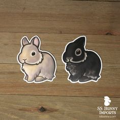 two stickers depicting rabbits on a wooden surface