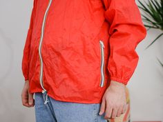 "UNCLE ED PRESENTS - vintage 90's red windbreaker/raincoat - the hood hidden in the collar - 2 outside pockets - materials: 100% nylon CONDITION (1-10 ❶❷❸❹❺❻❼❽ Good condition. The jacket is washed and ready to wear. SIZE/MEASUREMENTS size from label: 52/54 best fits men: L/XL chest: 50,5 inches (128 cm) length: 29 inches (74 cm) sleeve length from armpit: 21,5 inches (55 cm) The model is 6'3\" (190 cm), measures 45-36-43,5 (114-92-110 cm) and wears size L and XL WE SHIP WORLDWIDE FOLLOW US: inst Red Nylon Streetwear Windbreaker, Red Nylon Windbreaker For Streetwear, Red Windbreaker For Spring Outdoors, Red Hooded Nylon Windbreaker, Red Spring Windbreaker For Outdoor, Red Nylon Windbreaker With Adjustable Hood, Red Hooded Raincoat For Outdoor, Casual Red Windbreaker With Adjustable Hood, Red Nylon Windbreaker For Spring