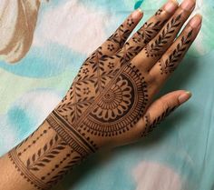 a woman's hand with henna tattoos on it