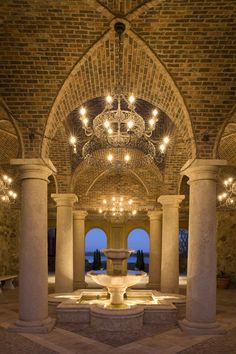 the inside of an old brick building with chandeliers