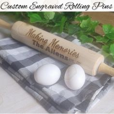 three white eggs sitting on top of a table next to a rolling pin