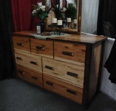 the dresser is made out of wood and has candles on it