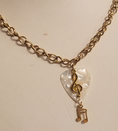 "This is one gorgeous White Guitar Pick Necklace! This guitar pick is Celluloid. The bracelet is Golden Stainless Steel Chain, Lobster clasp and Jump rings. The charms are Golden Tibetan alloy. There is also a jazzy note charm.   I love the treble clef music charm on this beautiful White Guitar Pick Necklace is great for the music lover in your life!   You can also add more charms to this Guitar Pick necklace. This Guitar Pick Necklace measures 24 inches long and can worn shorter by clipping int Nirvana Guitar, Treble Clef Necklace, Necklace Music, White Guitar, Guitar Pick Jewelry, Pick Necklace, Guitar Pick Necklace, Treble Clef, Music Lover