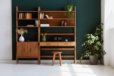 a wooden desk sitting next to a book shelf filled with books and vases on top of it