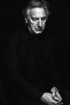 black and white photograph of a man in a suit sitting down with his eyes closed