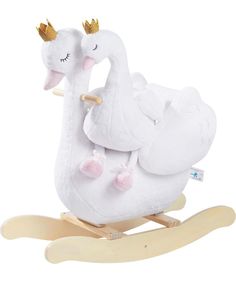 a white swan rocking toy with gold crowns on its head and body, sitting on a wooden sled