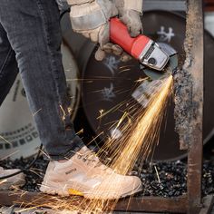 a person using a grinder on metal with sparks coming out of the top and bottom