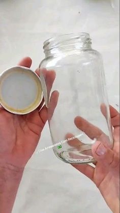 a person holding a glass jar with a lid in their left hand and another one on the other side