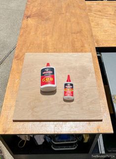 two bottles of glue sitting on top of a wooden table