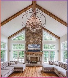 a living room filled with lots of furniture and a chandelier hanging from the ceiling