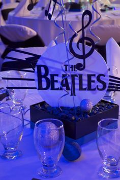 the table is set with glasses, silverware and paper napkins that read'the beatles '