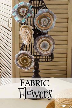 fabric flowers are sitting on top of a wire rack with the words fabric flowers above it