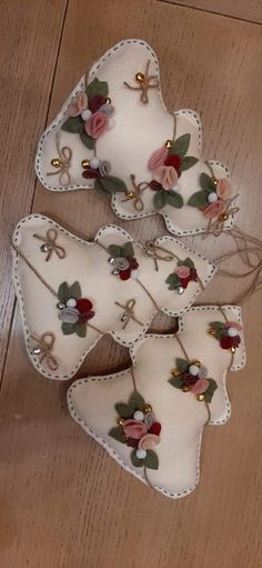 four pieces of white fabric with flowers on them sitting on top of a wooden floor