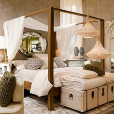 a bedroom with four poster bed and lots of pillows