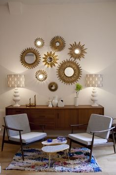 a living room filled with furniture and mirrors on the wall