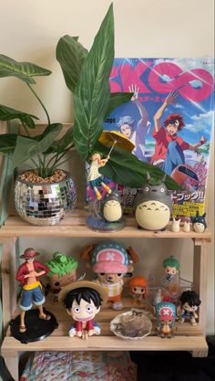 a shelf filled with figurines and toys on top of a bed next to a plant