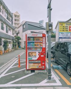 a vending machine is on the side of the road next to a parked car