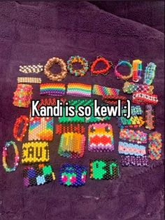 many bracelets and rings are laid out on a purple blanket with the words kandi is so kewl